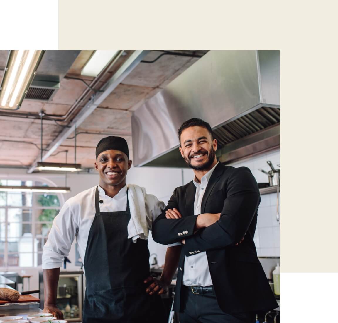 A chef and restaurant owner standing in a kitchen